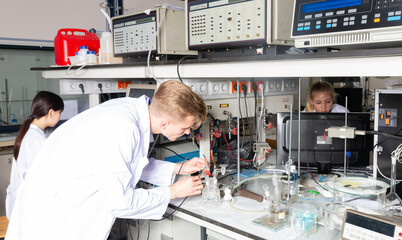 View of modern university research laboratory with multiracial group of chemists performing experiments on lab equipment
