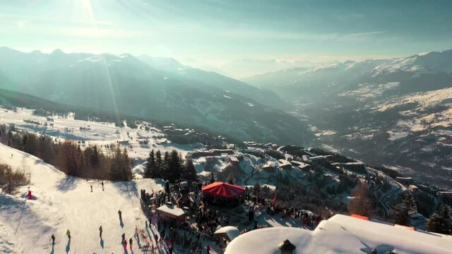 Mountain ski bar overlooking beautiful snowy valley, aerial reveal