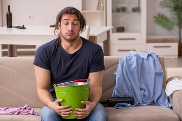 Young alcohol addicted man suffering from stomachache at home