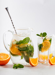 Orange and mint lemonade in a jug and glass 