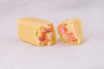 Delicious mini Battenberg cake, the tradional sweet afternoon tea snack. Pink and yellow sponge cake covered in jam wrapped in almond marzipan.
