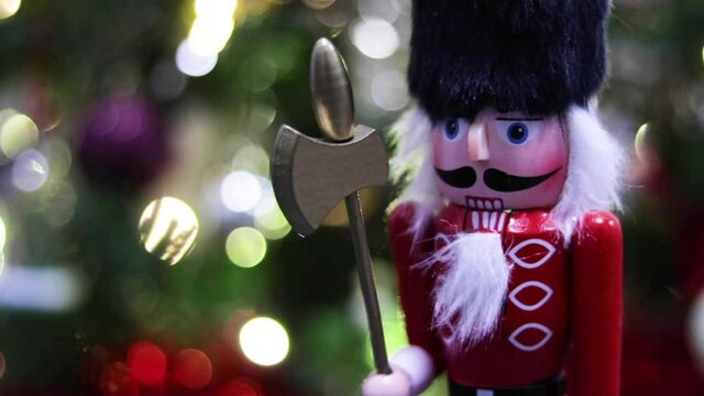 Large Christmas nutcracker in front of a Christmas Tree. Slider shot.
