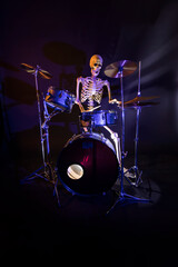 White skeleton against a dark background playing a drum set