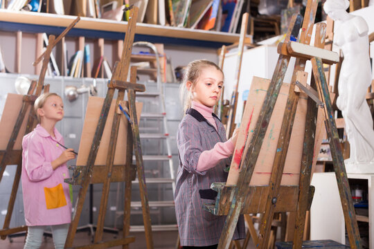 Young schoolgirl practicing their skills during painting class at art studio