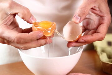 Separating egg yolk from white. Making mayonnaise with a wooden spoon.