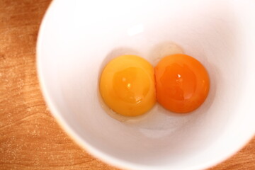 Separating egg yolk from white. Making mayonnaise with a wooden spoon.