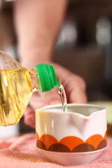 Pouring oil into sauce boat. Making mayonnaise with a wooden spoon.