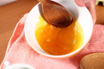 Mixing yolks with sugar and salt. Making mayonnaise with a wooden spoon.