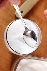 Teaspoon of salt. Making mayonnaise with a wooden spoon.
