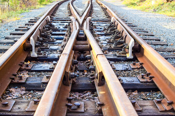 Image of an empty railroad track stretching far away. Crossing railway tracks. Narrow gauge railway.
