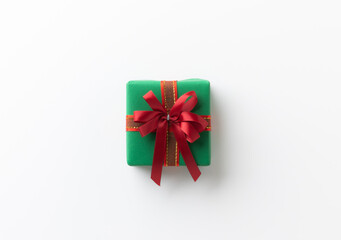 Top view green present gift box with red ribbon on the white table background. Merry christmas and Happy new year theme.