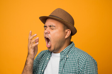 Tourist man on vacation bored yawning tired covering mouth with hand isolated on yellow background