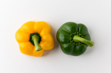 Raw green and yellow bell pepper on white table. Healthy vegetables and food.