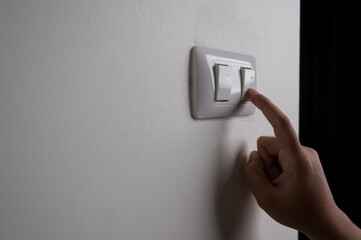 Earth Hour, Close up male hand turn off the light to saving electrical energy. Finger pushing light...