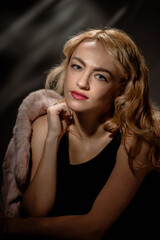 Fototapeta premium Young elegant retro woman posing with fur coat