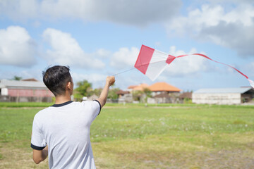 portrait of a young man playing a kite in a rice field
