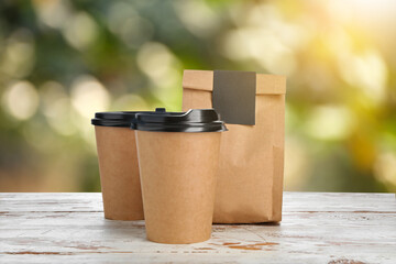 Paper bag and cups for coffee on table outdoors