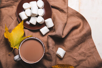 Cup of hot cacao drink with marshmallows on table