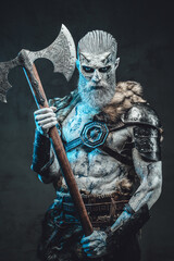 Shirtless and risen from the dead warrior with iced skin and horns in dark armour holding two...