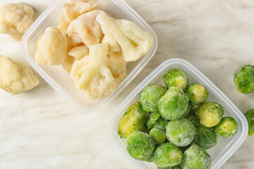 Bowls with different frozen vegetables on white background