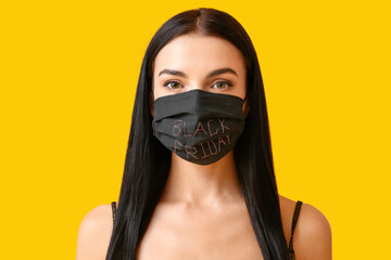 Beautiful young woman in medical mask on color background. Black Friday sale