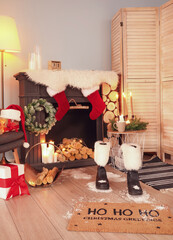 Boots of Santa and his footprints on floor in room decorated for Christmas