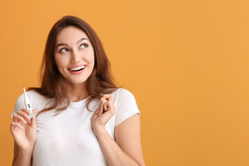 Obraz premium Young woman with thermometer on color background