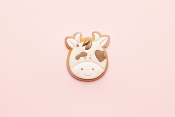 Tasty Christmas cookie in shape of bull on color background