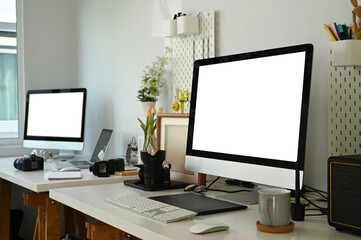 Graphic design or photographer  work station with blank screen desktop compute and camera accessory.