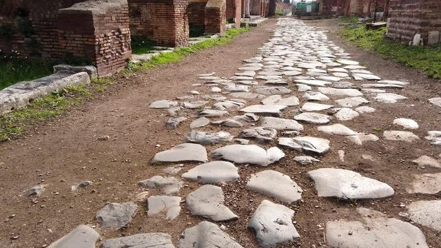 Roman road stone-paved separating insulae in the huge and world famous archaeological site of Ostia antica in the outskirts of Rome.