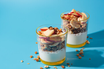 Proper nutrition, breakfast. Wellness - granola with yoghurt and fruits: banana and apple, in glass...