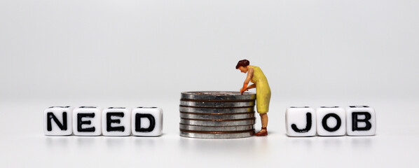 A concept about job shortages. A miniature woman standing with a pile of coins between a 'NEED'...