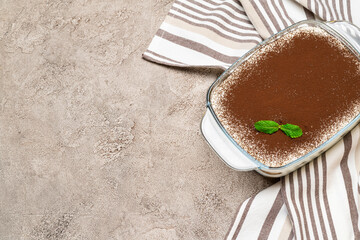 Traditional Italian Tiramisu dessert in glass baking dish on concrete background