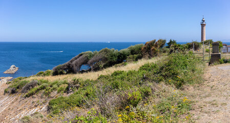 The lighthouse at Punta Canero in southern Spain. It's a hazy summer day. In the background is the...