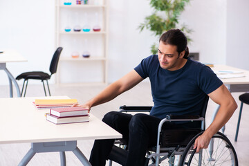 Young male student in wheel-chair preparing for exams