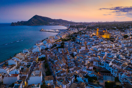Scenic aerial view at twilight of Altea cityscape on Mediterranean coast overlooking illuminated Church of La Mare de Deu del Consol, Spain