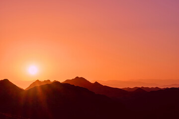 Rising sun over the mountain ridges as a background