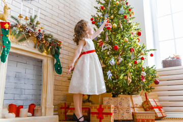 girl is decorating Christmas tree