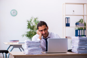 Naklejka premium Young male employee unhappy with excessive work