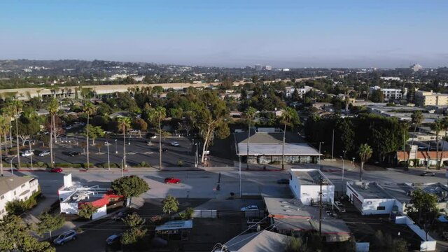 Aerial static shot over streets and neighborhood houses in Los Angeles suburbs, in California, USA, Sunset, drone shot