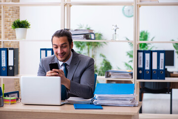 Young male employee and too much work in the office