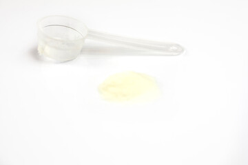cologen powder for face rejuvenation with measuring spoon on white background