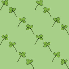 Seamless pattern with clover leaves on light green background. Vector image.