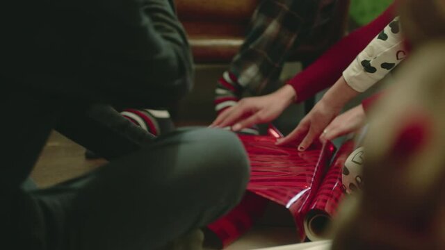 A family wrapping Christmas gifts