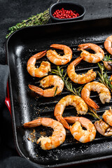 Fried king prawns, shrimps in a pan. Black background. Top view