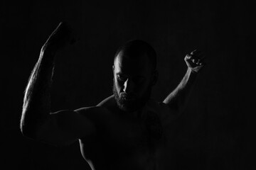 Low-key studio shot of muscular man