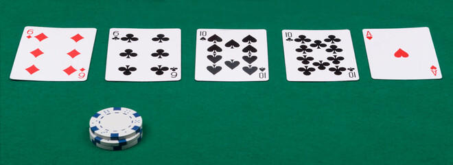 a combination of poker cards and chips is laid out on a green cloth