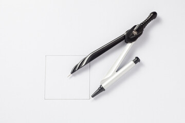 Pair of compasses draw a square on a paper