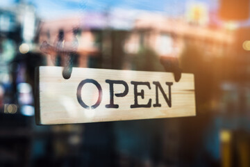 A business sign that says ‘Open’ on cafe or restaurant hang on door at entrance.