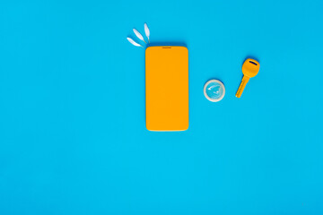 Flat lay composition with condom, key, phone on a blue background. Erotic concepts